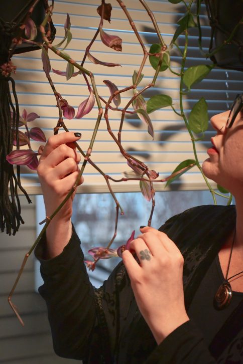 Olexia thoughtfully tending to her plants.